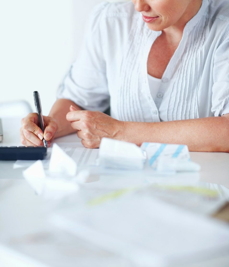Busy calculating taxes. Mature female executive busy calculating taxes in office.