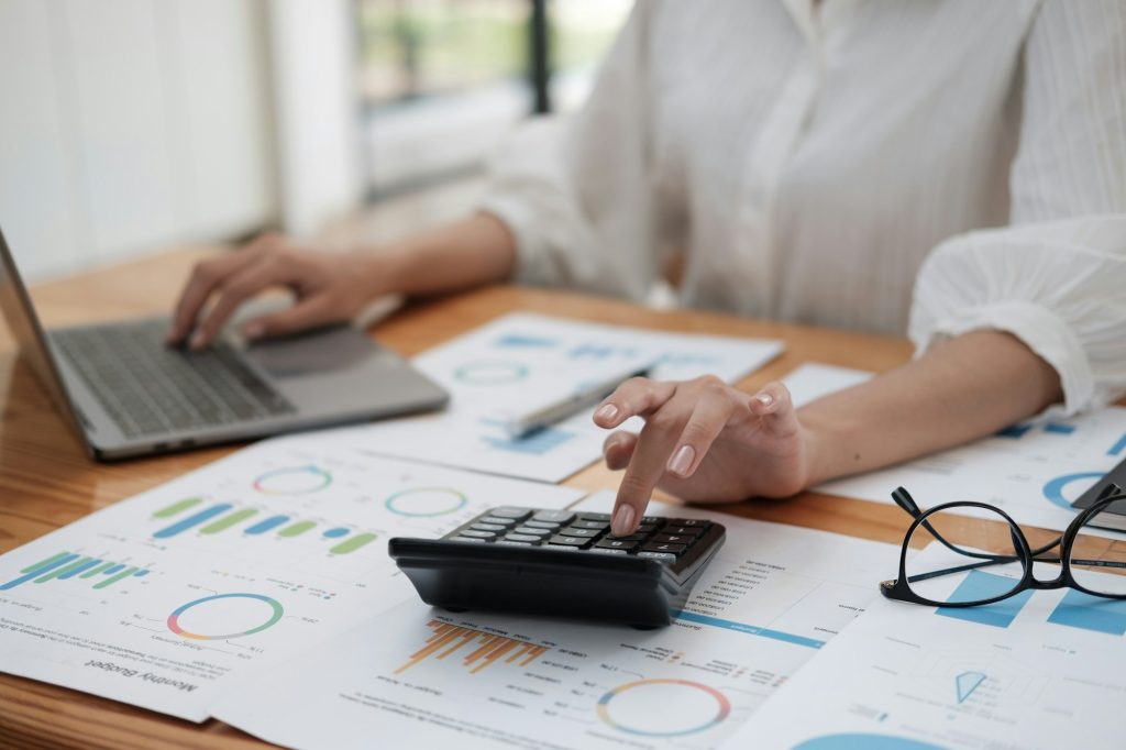Close up businesswoman hand using calculator and working with laptop calculate about finance accoun