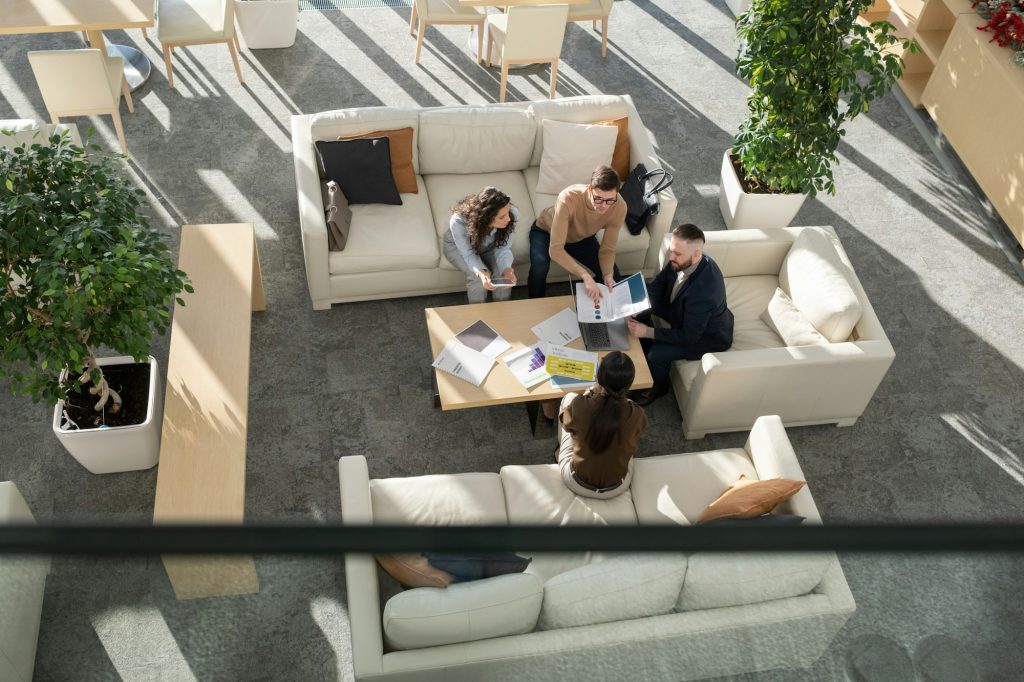 Contemporary young businessman explaining group of colleague data in document